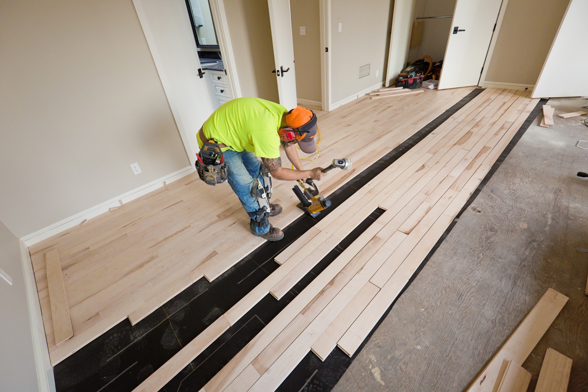 Installation of Maple Hardwood Flooring with Nail Gun in Progress